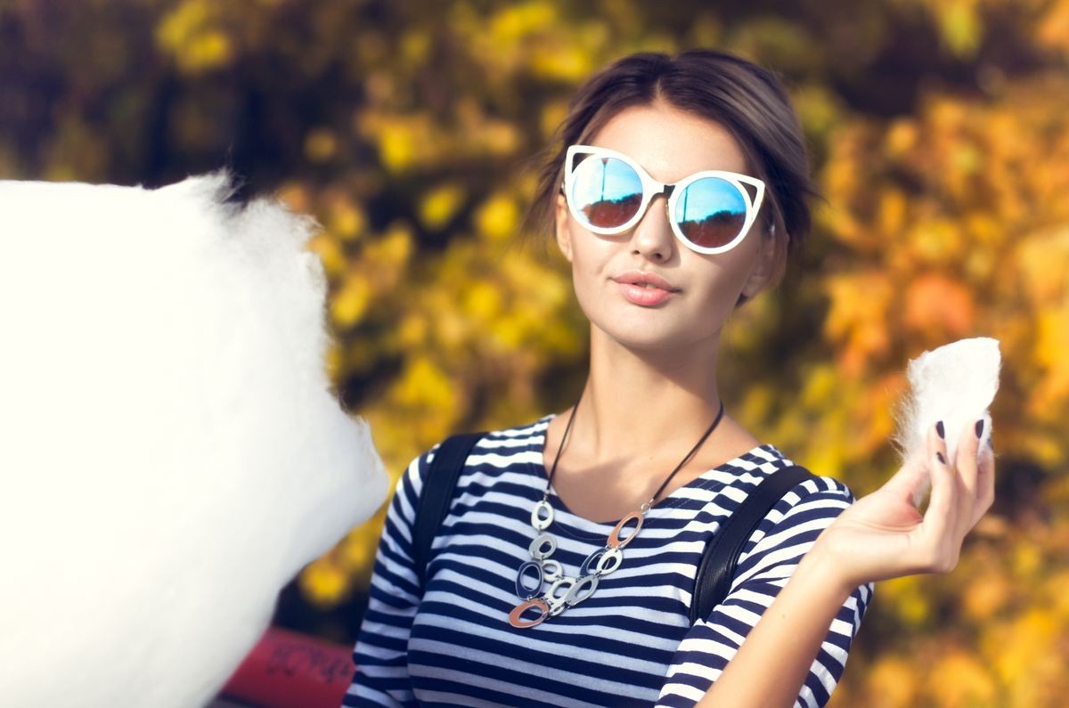 Teenage girl eating cotton candy in a city park